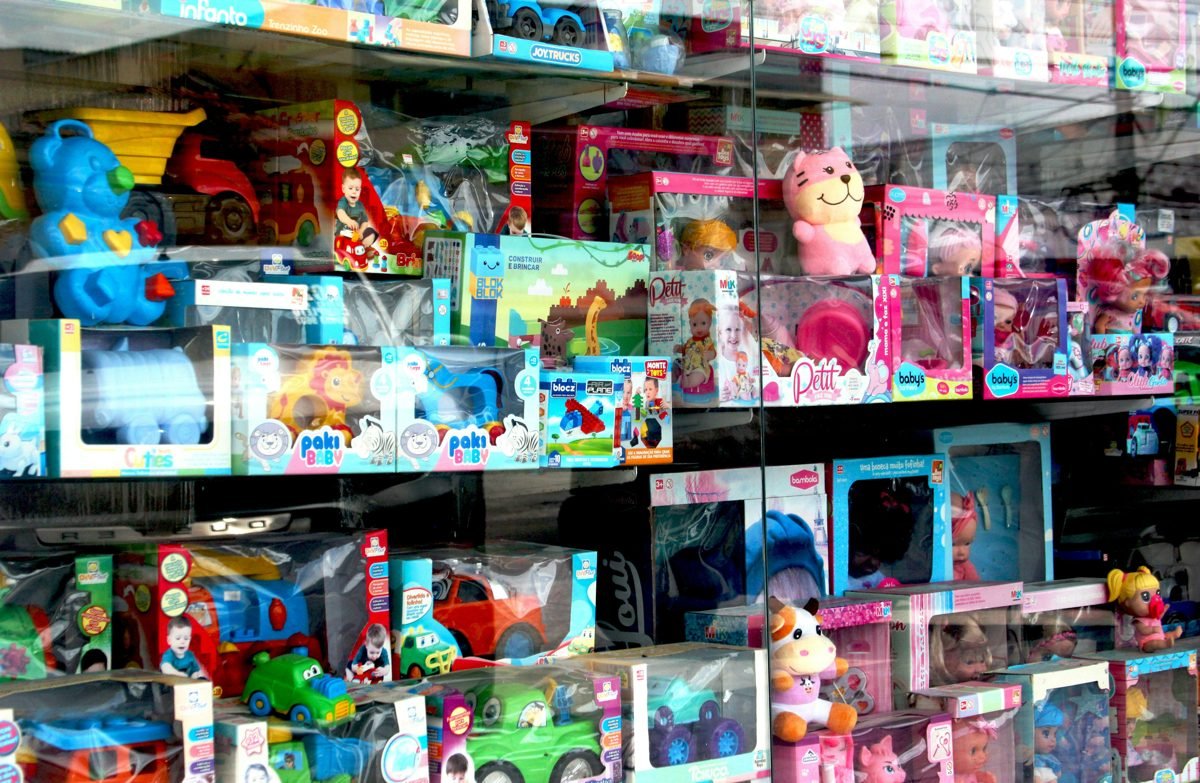 Shelves packed with colorful boxed toys and dolls in a toy store window, illustrative photo